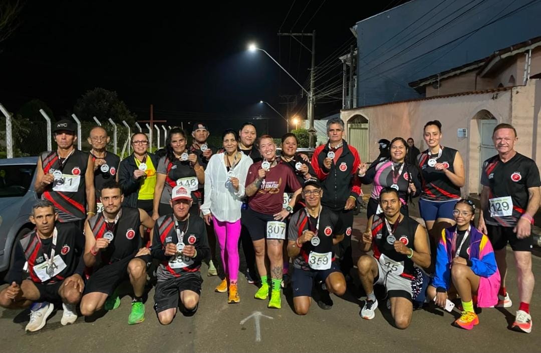 Equipe ACCB à noite exibindo medalhas e o troféu de 2º lugar maior equipe